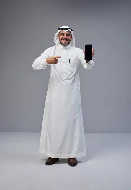 رجل سعودي بالزي التقليدي يحمل هاتف بشاشة فارغة
