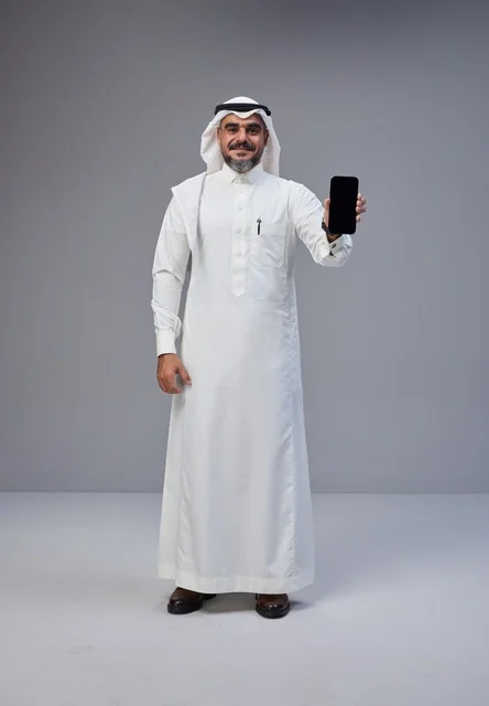 Saudi Man in Traditional Thobe Holding Blank Smartphone