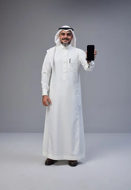 Saudi Man in Traditional Thobe Holding Blank Smartphone