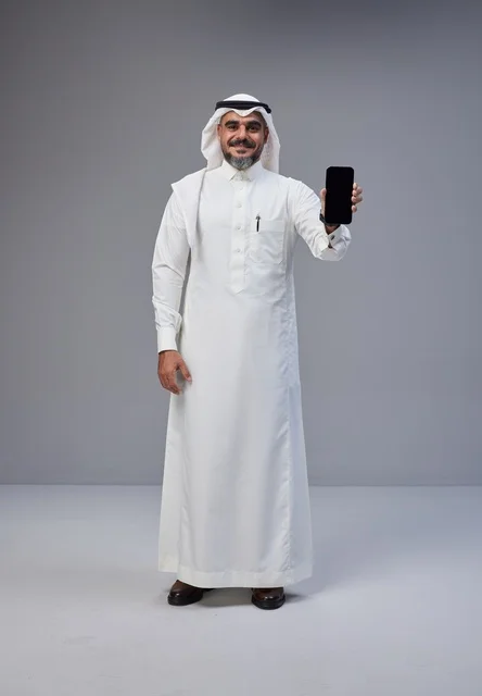 Saudi Man in Traditional Thobe Holding Blank Smartphone