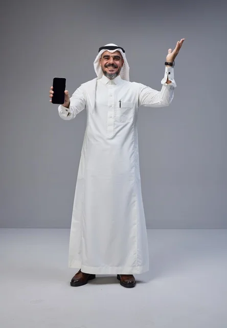 Saudi Man Holding Smartphone with Blank Screen in Studio
