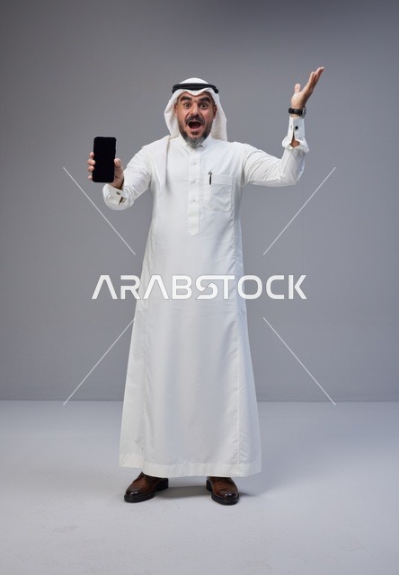 Saudi Man Holding Blank Smartphone Screen on Grey Background
