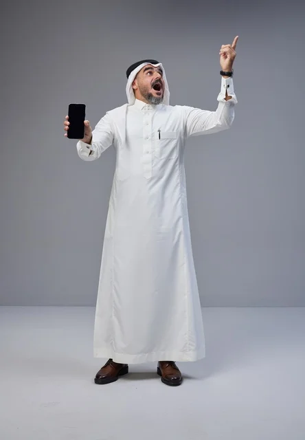 Saudi Man with Smartphone Pointing Upwards Studio
