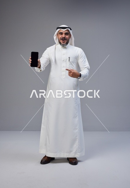 Saudi Man in Traditional Thobe Holding Smartphone Mockup