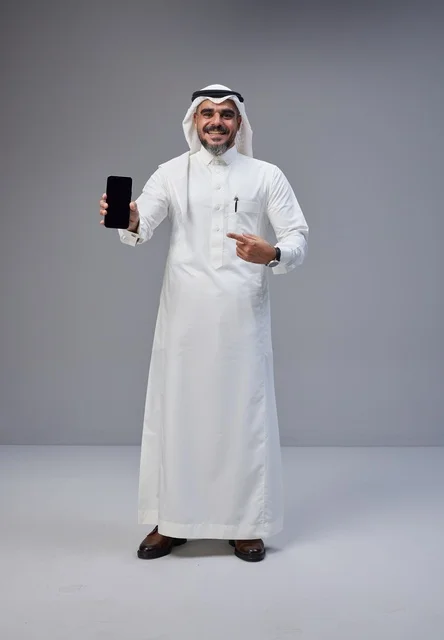 Saudi Man in Traditional Thobe Holding Blank Smartphone
