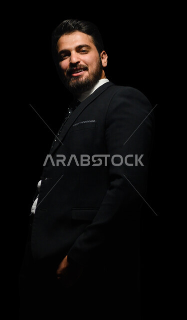 بورتريه لرجل أعمال عربي يرتدي بدلة أنيقة ، يقف بإستقامه , ينظر إلى الكاميرا ، الوقوف بثقه , ملامح مخفية ضبابية ، خلفية سوداء