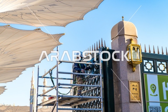 Worker Maintaining Prophet's Mosque Gate in Medina