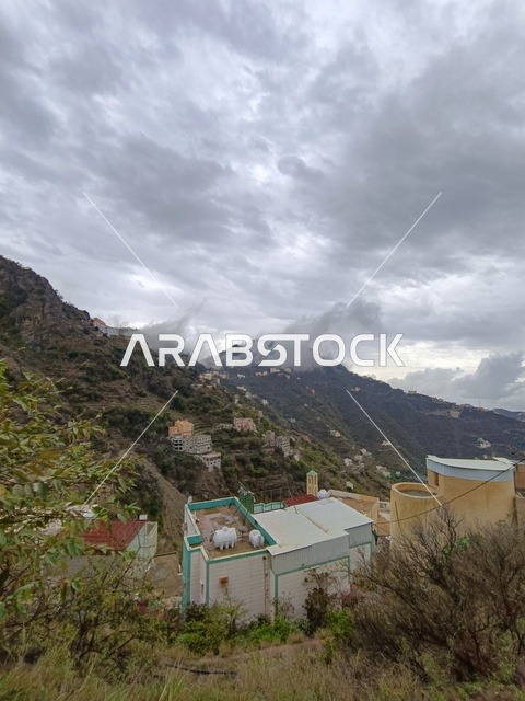 قرية جبلية في جازان تحت سماء غائمة