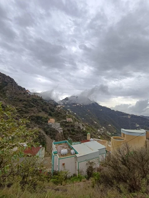 قرية جبلية في جازان تحت سماء غائمة