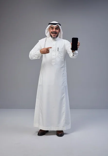 Saudi Man in Traditional Thobe Pointing to Smartphone