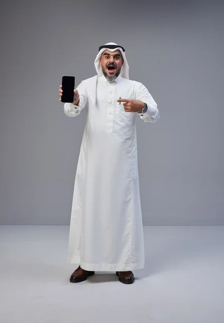 رجل سعودي متحمس يحمل هاتف بشاشة فارغة