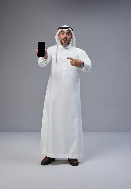 Saudi Man Pointing at Blank Smartphone Screen on Grey