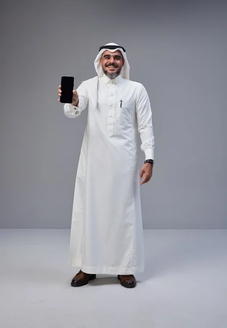 Saudi Man in Traditional Thobe Holding Blank Smartphone