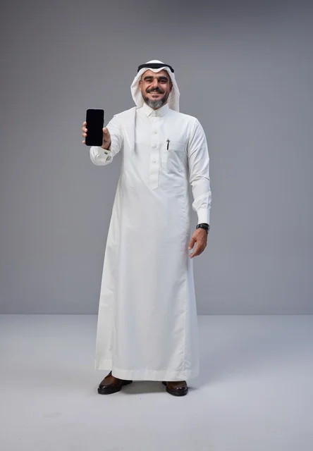 Saudi Man in Traditional Thobe Holding Blank Smartphone