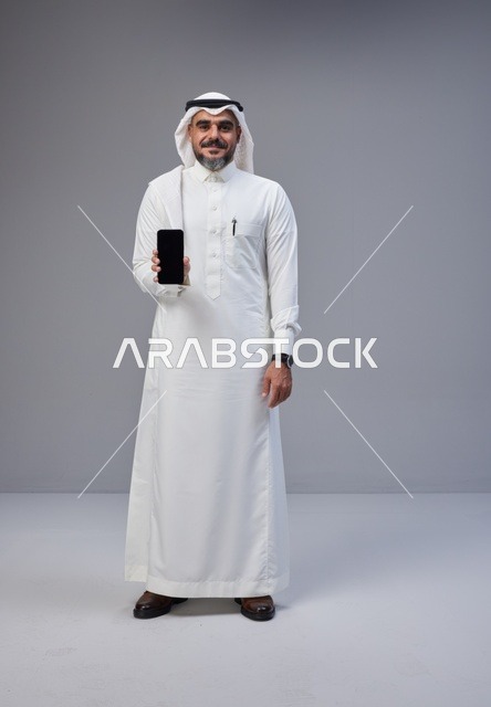 Saudi Man in Traditional Thobe Holding Smartphone Mockup