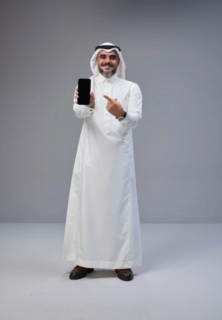 رجل سعودي يشير إلى شاشة هاتف فارغة