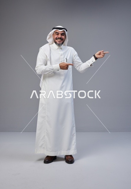 رجل سعودي بالزي التقليدي يشير بيده في الاستوديو