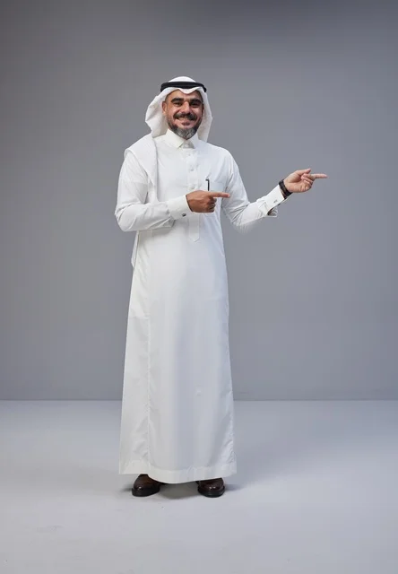 Saudi Man in Traditional Thobe Pointing Side in Studio