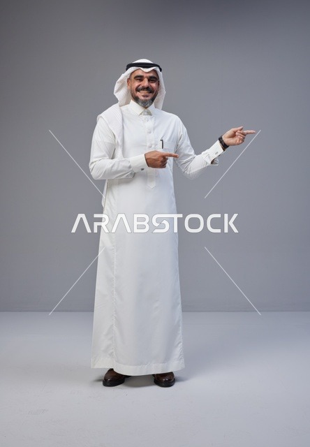 Saudi Man in Traditional Thobe Pointing in Studio