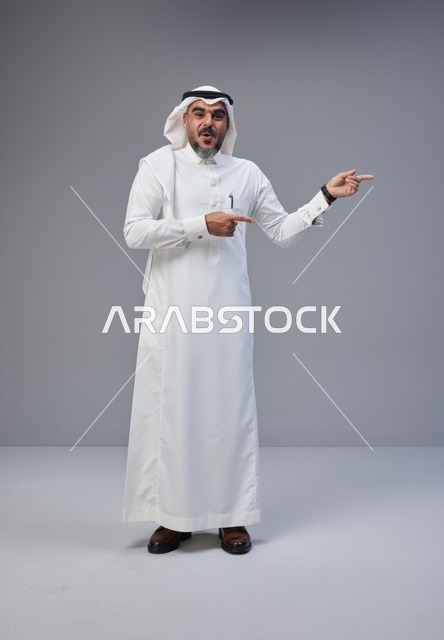 رجل سعودي يشير للجانب بتعبير وجه مندهش