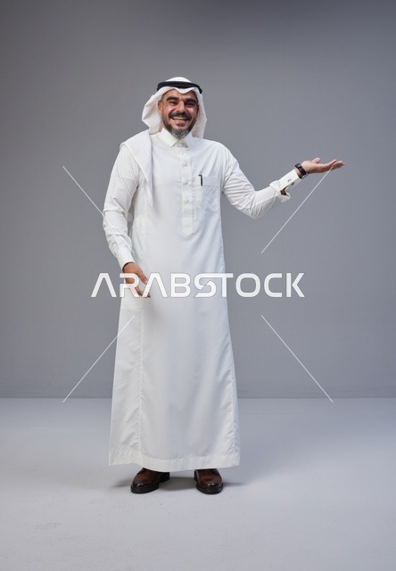 Smiling Saudi Man in Traditional Dress Gesturing to Side