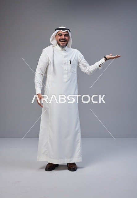 رجل سعودي بالزي التقليدي يشير بيده في الاستوديو
