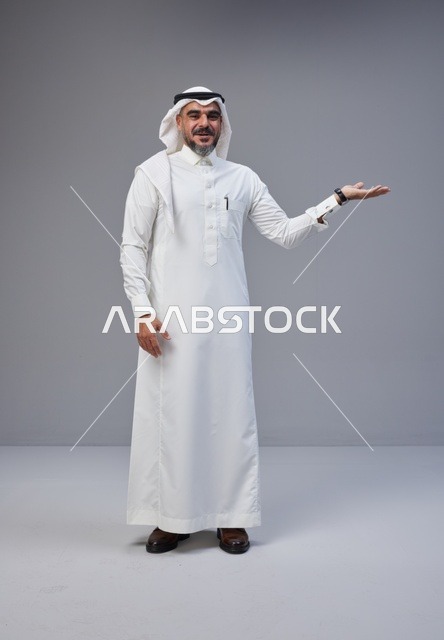 رجل سعودي بالزي التقليدي مع إيماءة يد للتقديم والعرض