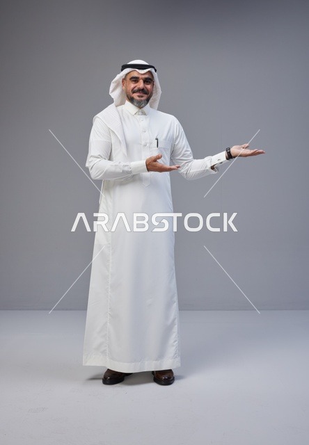 Saudi Man in Traditional Thobe Gesturing on Grey Background