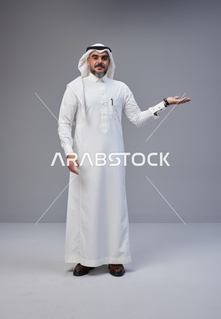 رجل سعودي بالزي التقليدي يشير بيده في الاستوديو