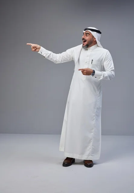 رجل سعودي بالزي التقليدي يشير بتعبير متفاجئ