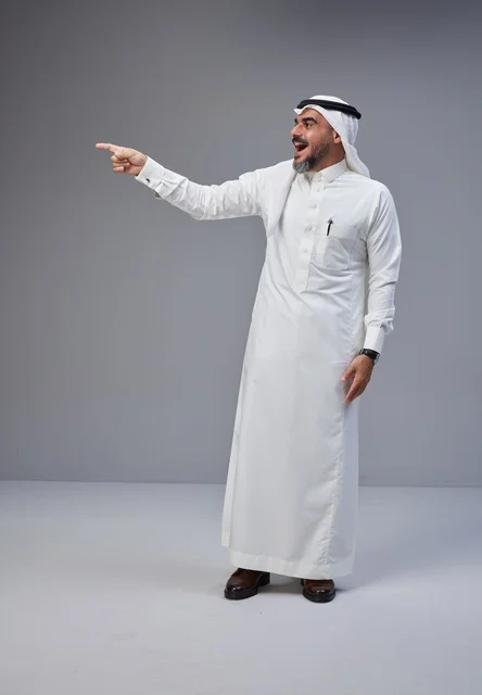 Excited Saudi Man Pointing in Traditional Clothing Studio