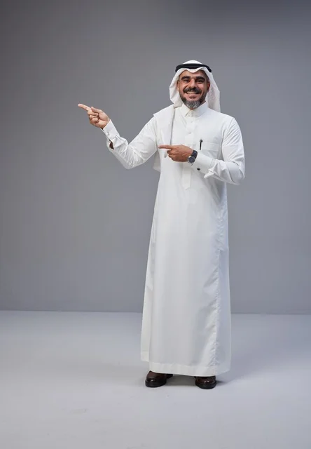 رجل سعودي بالزي التقليدي يشير على خلفية رمادية