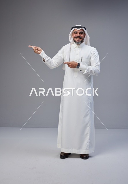 رجل سعودي بالزي التقليدي يشير في الاستوديو