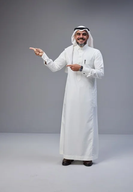 رجل سعودي بالزي التقليدي يشير في الاستوديو