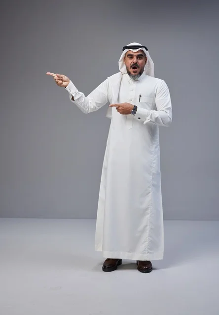 رجل سعودي بالزي التقليدي يشير بتعبير مندهش