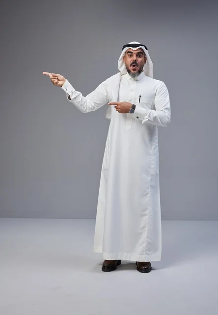 رجل سعودي بالثوب التقليدي يشير بتعبير وجه مندهش