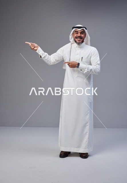 رجل سعودي بالثوب التقليدي يشير بيده داخل استوديو