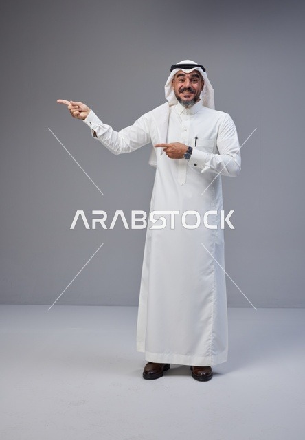 Saudi Man in Traditional Thobe Pointing Side Studio