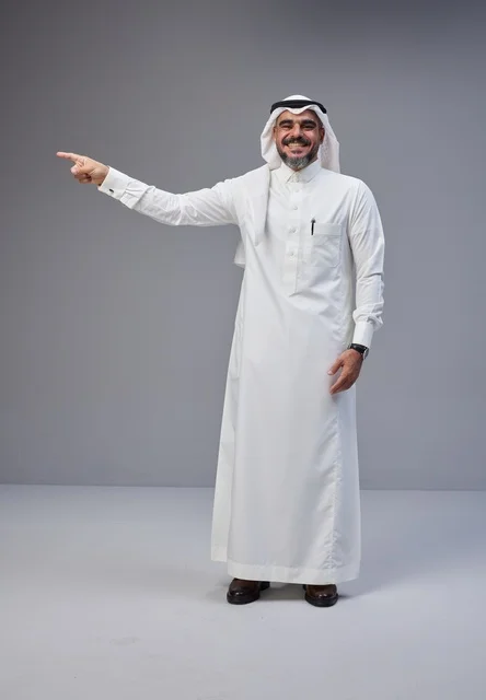 رجل سعودي بالزي التقليدي يشير بيده في الاستوديو