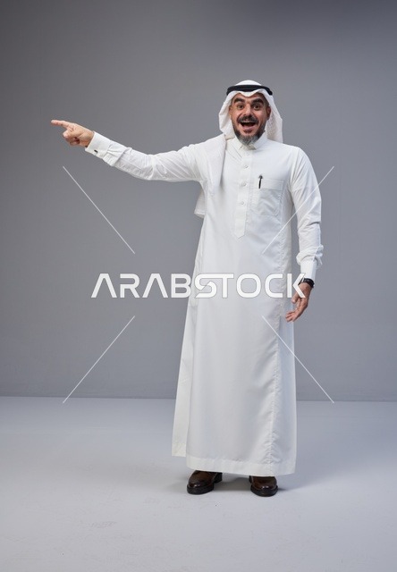 رجل سعودي بالزي التقليدي يشير بتعبير متحمس