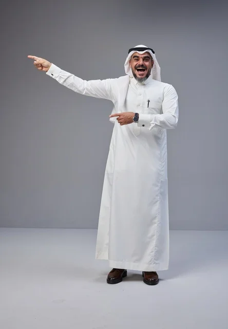 رجل سعودي بالثوب التقليدي يشير في الاستوديو