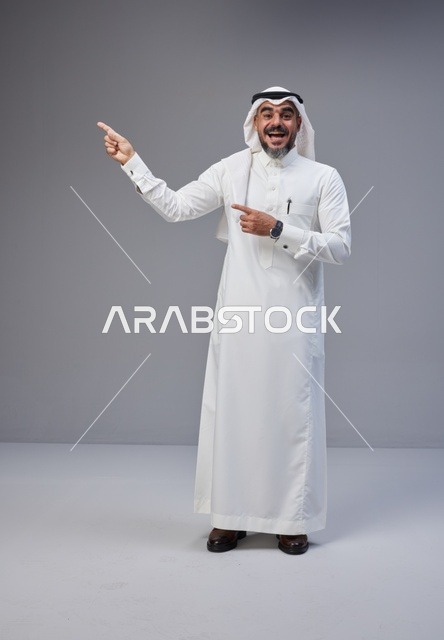 رجل سعودي بالزي التقليدي يشير بيده في الاستوديو