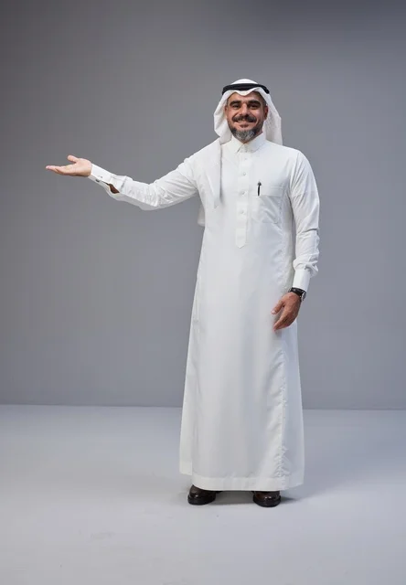 رجل سعودي بالزي التقليدي يشير بيده في الاستوديو