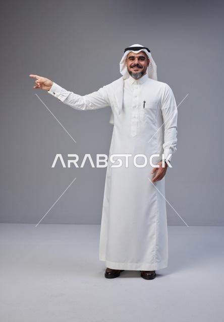 Saudi Man in Traditional Thobe Pointing in Studio