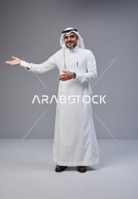 رجل سعودي بالزي التقليدي يشير بيده في استوديو
