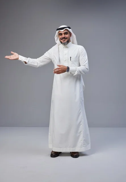 رجل سعودي بالزي التقليدي يشير بيده في استوديو