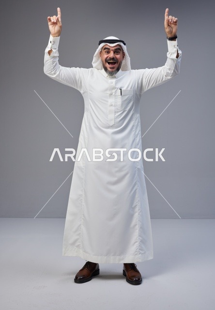 رجل سعودي بالزي التقليدي يشير للأعلى بحماس