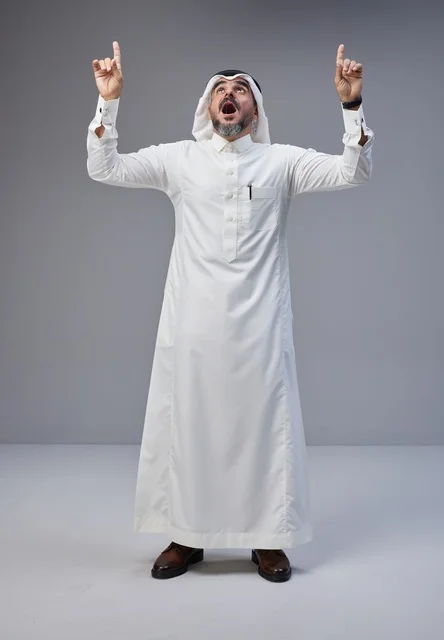 Saudi Man in Traditional Thobe Pointing Up in Surprise