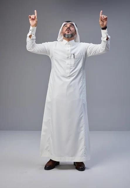 Saudi Man in Traditional Thobe Pointing Upwards in Studio