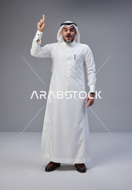 Saudi Man in Traditional Thobe Pointing Up Surprised